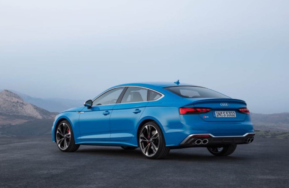 Audi S5 Sportback, blue color, rear view with fog and mountains in the background