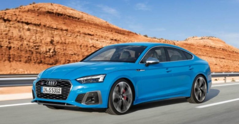 Audi S5 Sportback, blue color, running on the road with rocky mountains behind it